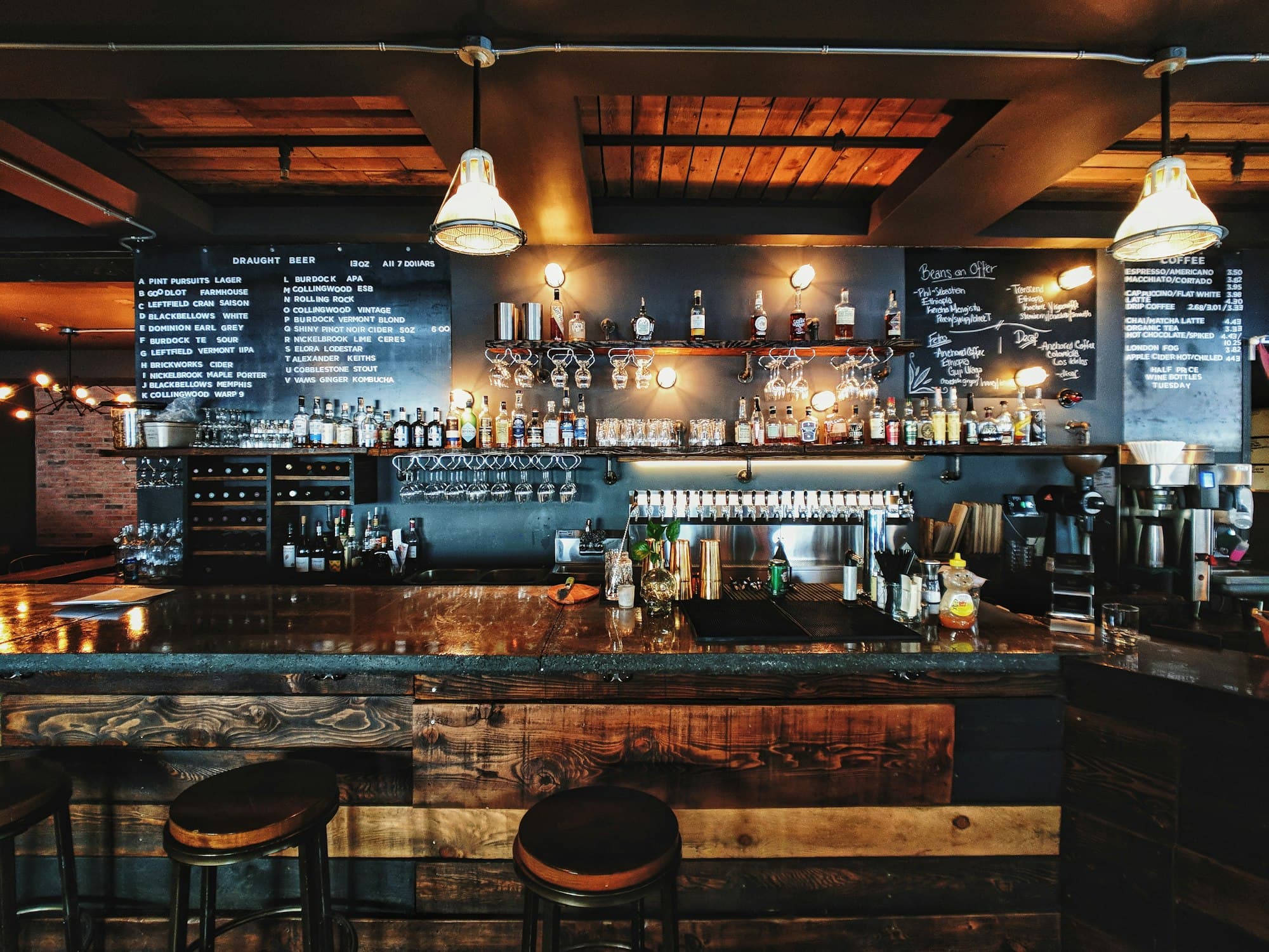 Bar d’hôtel avec tabourets et étagères de bouteilles